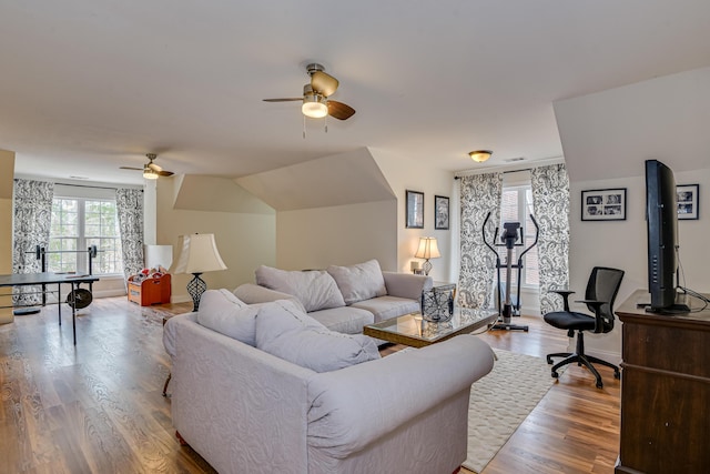 living room with hardwood / wood-style flooring, ceiling fan, and lofted ceiling