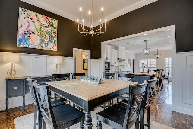 dining space featuring crown molding, dark hardwood / wood-style flooring, and sink