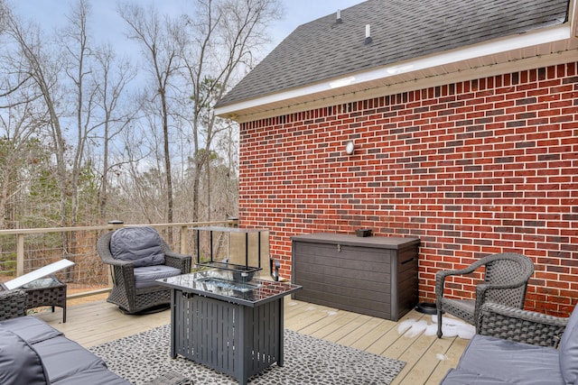 deck with an outdoor living space with a fire pit