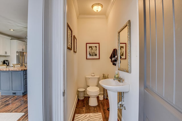 bathroom with hardwood / wood-style floors, toilet, and ornamental molding