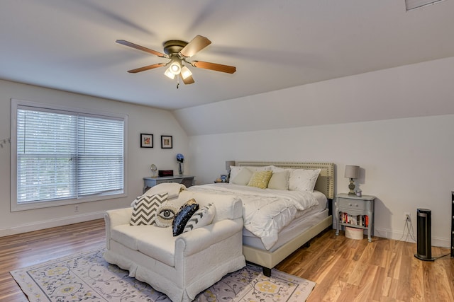 bedroom with ceiling fan, light hardwood / wood-style floors, and lofted ceiling