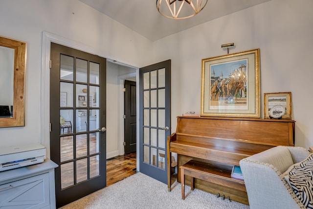 misc room featuring carpet flooring, a chandelier, and french doors