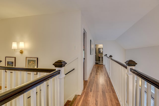 hallway featuring lofted ceiling and hardwood / wood-style flooring