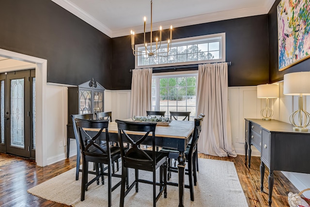 dining room with hardwood / wood-style flooring, an inviting chandelier, and ornamental molding