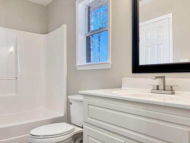 bathroom with toilet, vanity, and shower / bathing tub combination