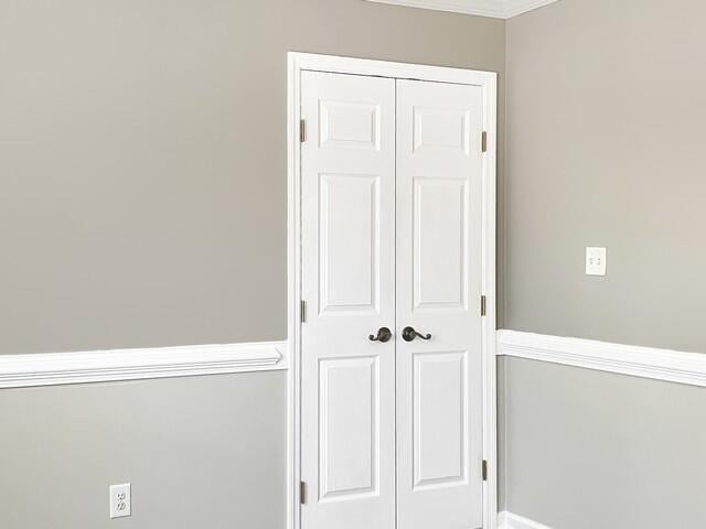 interior details featuring crown molding and baseboards