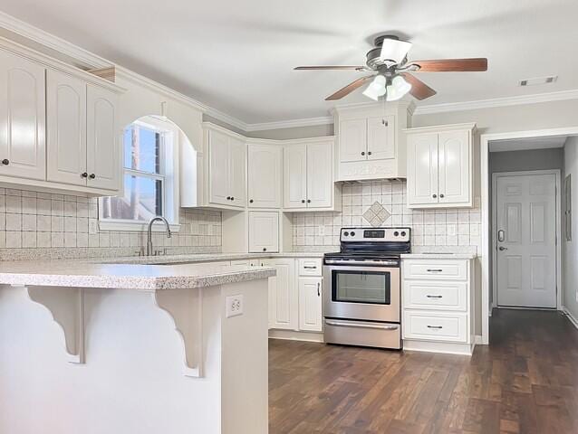 kitchen featuring dark wood-style flooring, light countertops, electric range, white cabinetry, and a kitchen breakfast bar