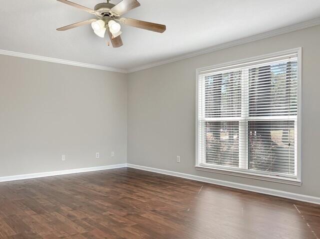 empty room with ornamental molding, dark wood-type flooring, baseboards, and a ceiling fan