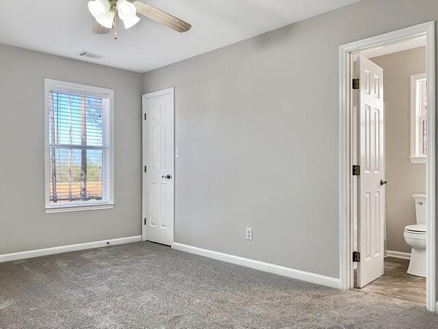 unfurnished bedroom featuring carpet, visible vents, baseboards, and ensuite bathroom