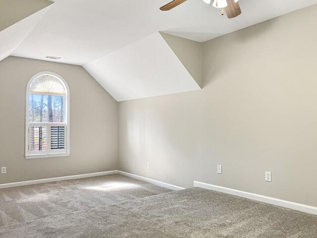 bonus room featuring carpet flooring, a ceiling fan, visible vents, vaulted ceiling, and baseboards