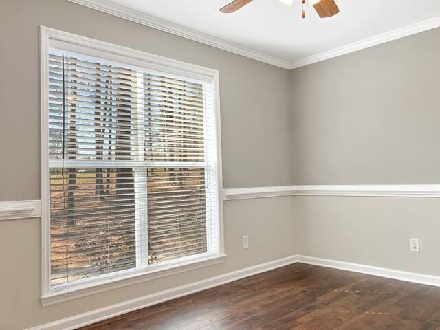 empty room featuring ornamental molding, dark wood-style flooring, ceiling fan, and baseboards