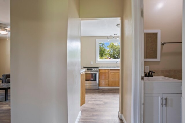 hallway featuring sink and light wood-type flooring