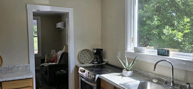 kitchen featuring sink, electric range, and light stone counters