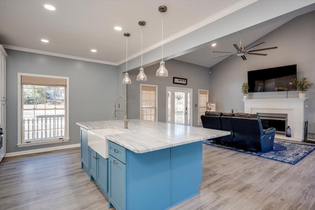 305 Kingfisher Pt, Mccormick, SC 29835 - kitchen with an island with sink, sink, hanging light fixtures, light hardwood / wood-style floors, and blue cabinetry