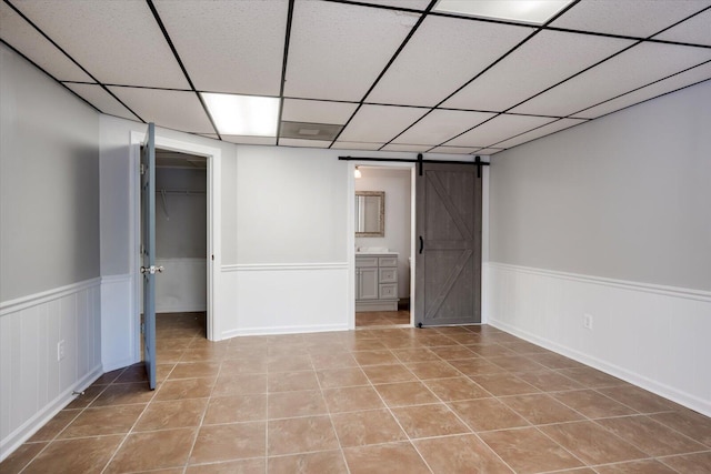305 Kingfisher Pt, Mccormick, SC 29835 - interior space with light tile patterned flooring, a paneled ceiling, and a barn door