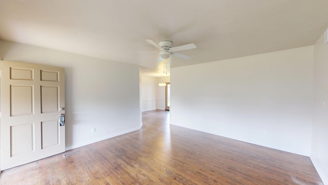 spare room featuring ceiling fan, wood finished floors, and visible vents