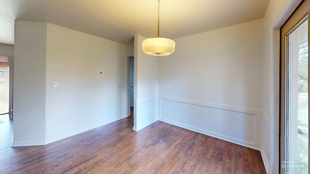 empty room featuring a wainscoted wall and wood finished floors