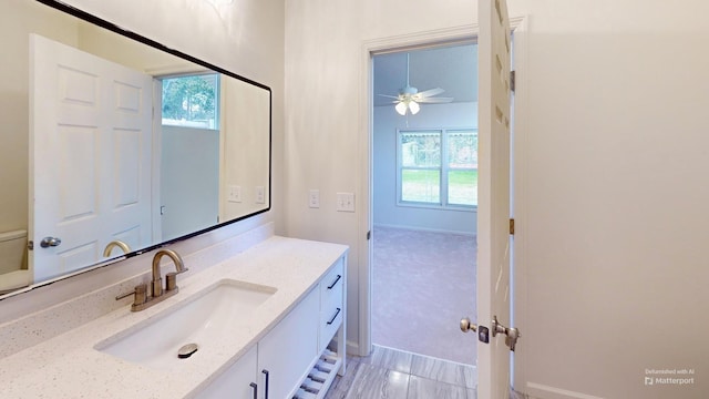 bathroom with toilet, a ceiling fan, a wealth of natural light, and vanity