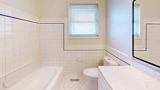 full bathroom featuring a tub, visible vents, tile walls, and toilet