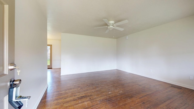 unfurnished room featuring wood-type flooring, visible vents, and ceiling fan