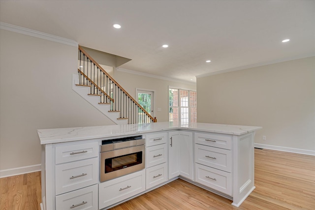 1 Bohler Ave, Evans, GA 30809 - kitchen featuring stainless steel microwave, ornamental molding, light wood finished floors, light stone countertops, and white cabinets