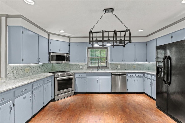 249 Usher Rd, Waynesboro, GA 30830 - kitchen featuring appliances with stainless steel finishes, hardwood / wood-style floors, crown molding, tasteful backsplash, and a chandelier