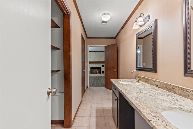 249 Usher Rd, Waynesboro, GA 30830 - bathroom featuring double vanity, a fireplace, ornamental molding, and a textured ceiling