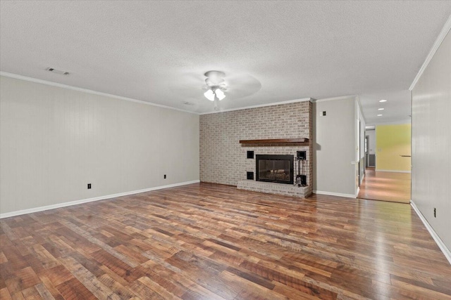 249 Usher Rd, Waynesboro, GA 30830 - unfurnished living room featuring wood finished floors, ceiling fan, crown molding, a textured ceiling, and a fireplace
