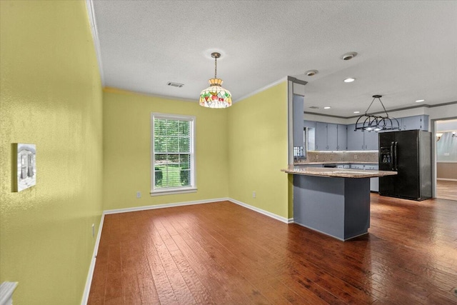 249 Usher Rd, Waynesboro, GA 30830 - kitchen with black fridge, dark wood-style flooring, a peninsula, tasteful backsplash, and gray cabinetry