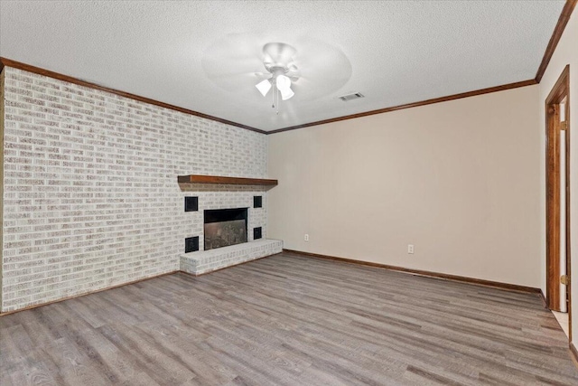 249 Usher Rd, Waynesboro, GA 30830 - unfurnished living room featuring ceiling fan, wood finished floors, crown molding, a fireplace, and a textured ceiling