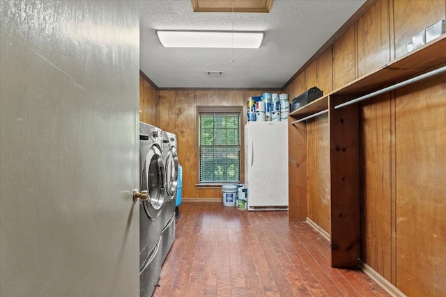 249 Usher Rd, Waynesboro, GA 30830 - washroom featuring washing machine and clothes dryer, wood-type flooring, a textured ceiling, and wooden walls
