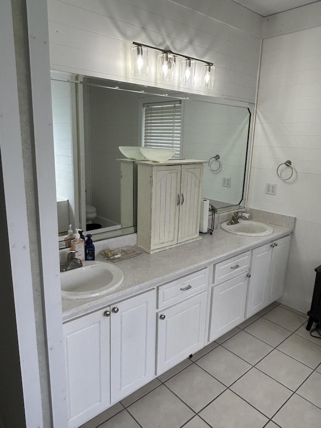 full bath with toilet, double vanity, and tile patterned floors