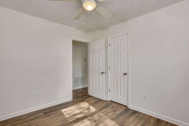 unfurnished bedroom featuring ceiling fan, wood-type flooring, and a textured ceiling