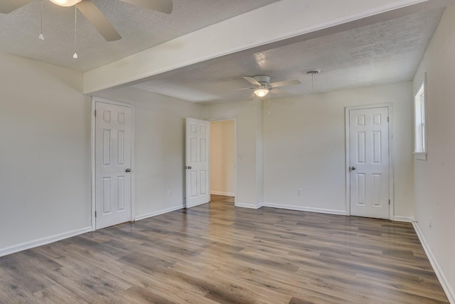 spare room with hardwood / wood-style floors, ceiling fan, and a textured ceiling