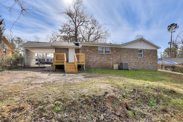 rear view of property with central air condition unit and a lawn