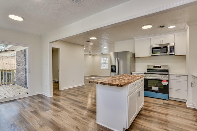 kitchen with wood counters, a center island, light hardwood / wood-style flooring, white cabinetry, and stainless steel appliances