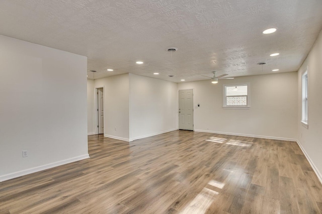 spare room featuring a textured ceiling, hardwood / wood-style flooring, and ceiling fan