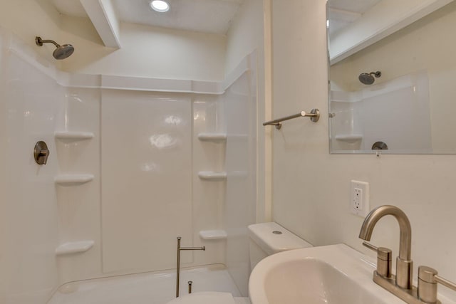 bathroom featuring toilet, sink, and walk in shower