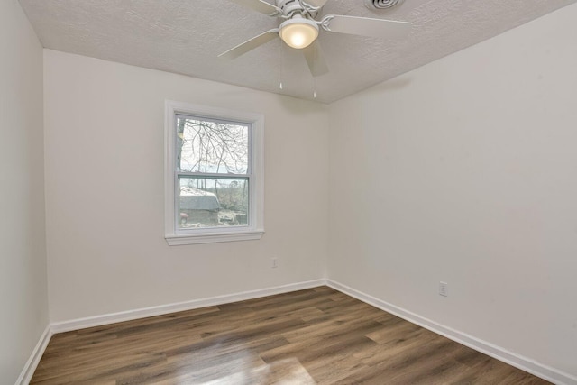 spare room featuring ceiling fan, dark hardwood / wood-style flooring, and a textured ceiling