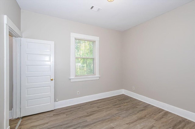 spare room with wood-type flooring