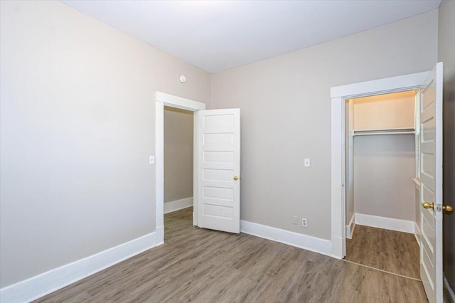 unfurnished bedroom with hardwood / wood-style floors and a closet