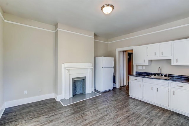 kitchen with white refrigerator, dark hardwood / wood-style flooring, white cabinetry, and sink