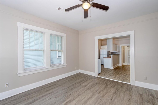 empty room with hardwood / wood-style floors and ceiling fan