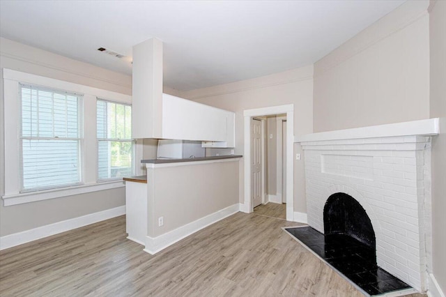 unfurnished living room with a fireplace and light hardwood / wood-style flooring