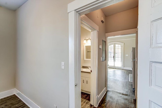 corridor featuring dark hardwood / wood-style flooring, sink, and french doors