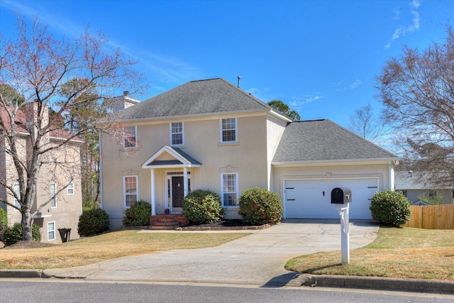 colonial house with a garage, a shingled roof, concrete driveway, fence, and a front lawn