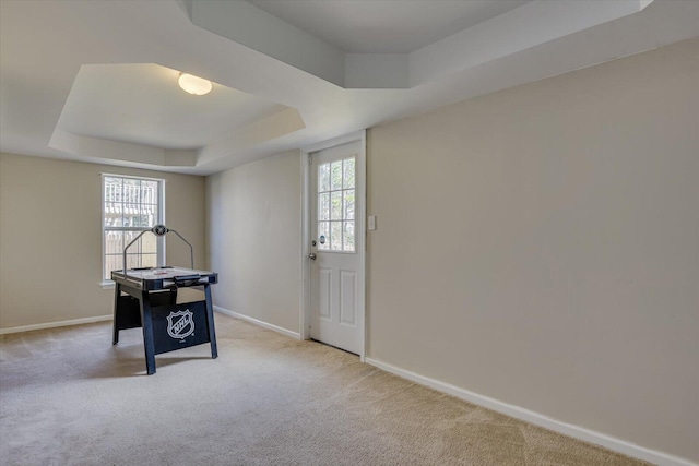 playroom with carpet floors, baseboards, and a raised ceiling