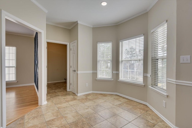 unfurnished room featuring ornamental molding, a wealth of natural light, and baseboards