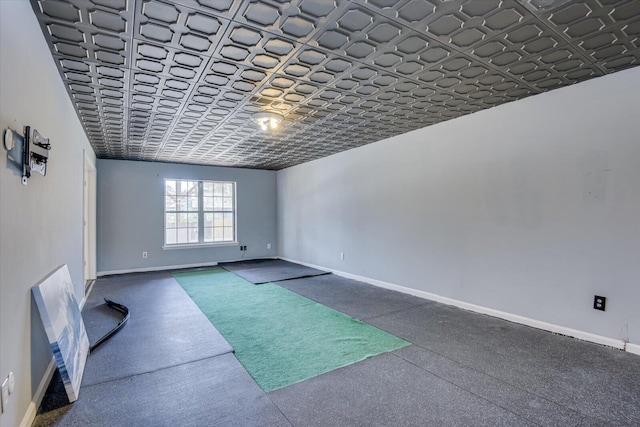 spare room with an ornate ceiling, baseboards, and speckled floor