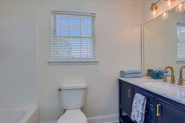 bathroom with toilet, vanity, baseboards, and bathing tub / shower combination